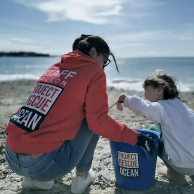 woman-child-cleaning-beach-400×400 Adultes et enfants nettoyant une plage